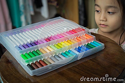 60 pieces of colorful markers in transparent plastic packaging on a wooden table Stock Photo