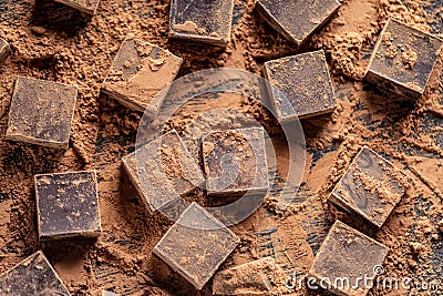 Pieces of dark bitter chocolate with cocoa powder on wooden background. Card with space for text Stock Photo