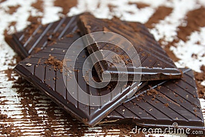 Pieces of dark chocolate with chocolate powder Stock Photo