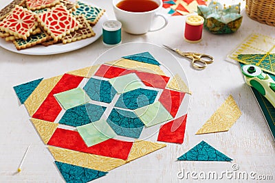 Pieces of fabric laid out in the shape of a patchwork block, a heap of cookies with a pattern imitating a patchwork block Stock Photo