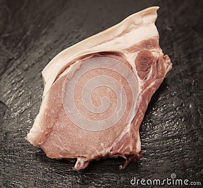 Pieces of fresh raw pork appetizing close-up on black stone background Stock Photo