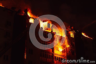 Pieces of the house fall due to the fire. Fire blazing in apartment house Stock Photo
