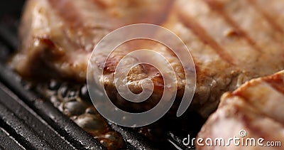 Pieces of meat are fried on a grill pan. Close-up dolly shot. Stock Photo