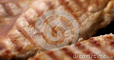 Pieces of meat are fried on a grill pan. Close-up dolly shot. Stock Photo