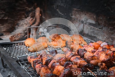 Pieces of meat, vegetable skewers and empanadas on the grill at a typical argentinian barbecue. Stock Photo