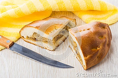 Pieces of pie with cabbage, yellow napkin and kitchen knife Stock Photo