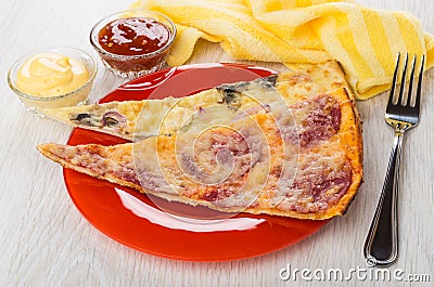 Pieces of pizza in plate, ketchup, mayonnaise inbowls, napkin, f Stock Photo