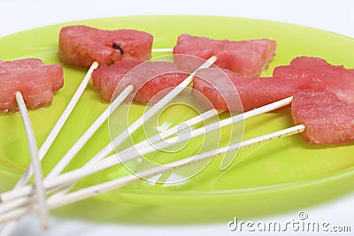 Pieces of the pulp of watermelon are cut with a stamp. They are given different forms. Stringed on skewers for a picnic. Stock Photo