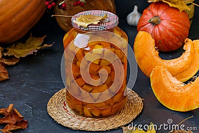 Pieces pumpkin in jar located on a dark background, harvesting vegetables for the winter, horizontal orientation Stock Photo