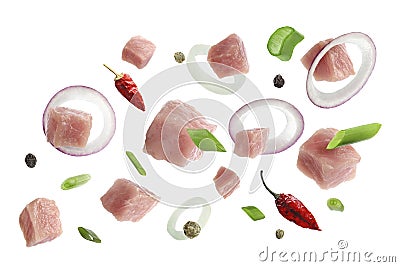 Pieces of raw pork and other ingredients for goulash flying on white background Stock Photo