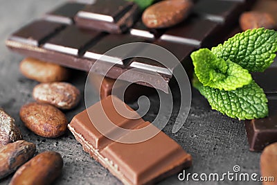 Pieces tasty chocolate and cocoa beans on table, closeup Stock Photo