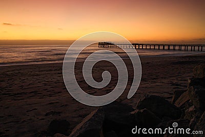 Pier on the Atlantic Ocean in Swakompund, Namibia. Beautiful sunset with a bright sky and soft gentle water Stock Photo