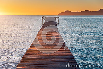 Pier in orange sunrise colors. Playa de Muro Stock Photo