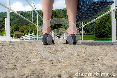 Pier seen between woman`s feet Stock Photo