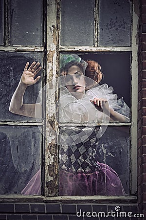 A pierrot woman behind the glass Stock Photo