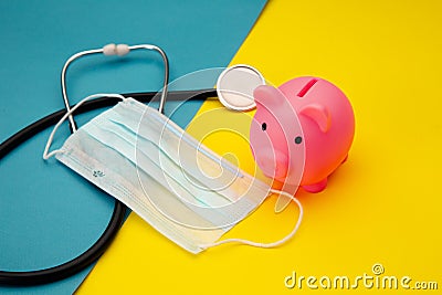 Pig moneybox, face mask and stethoscope on colorful background. Spending money on pills and expensiveness of medicine Stock Photo