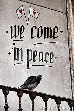 Pigeon perched on a balcony with peace message Stock Photo