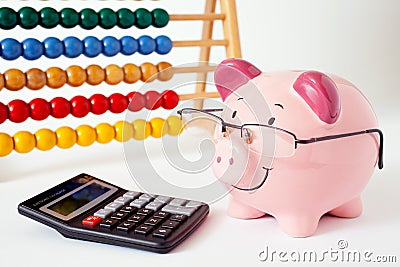 Piggy bank with calculator and abacus on white background. Stock Photo