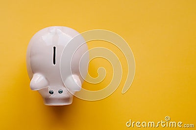 A piggy bank saving and investment theme on a yellow paper background Stock Photo