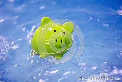 Piggy bank sinking in water drowning in debt Stock Photo