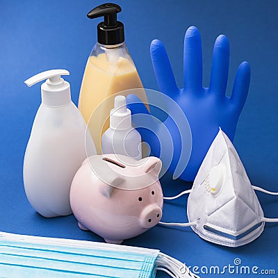 Piggy bank and various personal protective equipment on a blue background Stock Photo