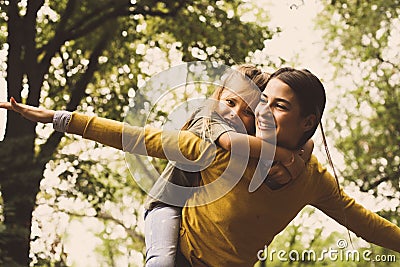 Piggyback ride. Happy single mother. Stock Photo