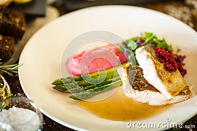 Pike-perch fillet. Asparagus, pearl couscous, white wine sauce, beet-flavored mashed potatoes. Delicious seafood fish Stock Photo