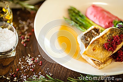 Pike-perch fillet. Asparagus, pearl couscous, white wine sauce, beet-flavored mashed potatoes. Delicious seafood fish Stock Photo