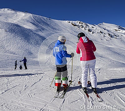 Female skier with a jacket written ITA which is short for Italy and pants with the italian flag at resort in sunny winter day Editorial Stock Photo