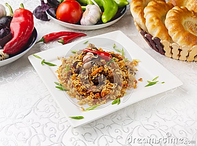 Pilaf with lamb meat, oriental lunch, fresh vegetables. Stock Photo