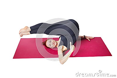 Pilates or yoga. A slender athletic girl is lying on the mat with her legs raised upside down. Stock Photo