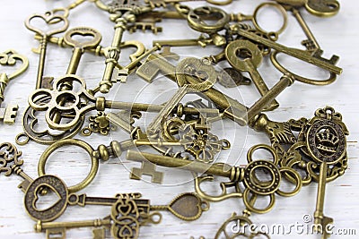 Pile of antique brass keys on a distressed wood background. Stock Photo