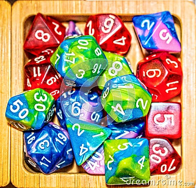 Pile of assorted gaming dice in wooden bowl - top down view Stock Photo