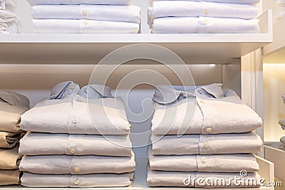 A pile of bluish shirts on a shelf Stock Photo