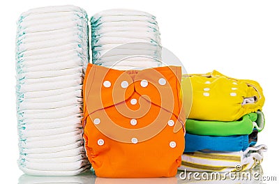 Pile cloth and disposable diapers on white. Stock Photo