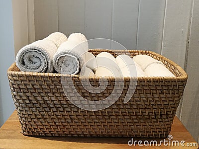 Pile of cloth, hand towel, table napkin, handkerchief on the basket in spa, bath room, toliet with blur white wooden wall backgrou Stock Photo