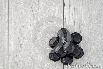 Pile of coal shaped candy on a gray washed wood background Stock Photo