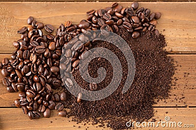 Pile of Coffee Beans and Grounds in Middle of Wood Stock Photo