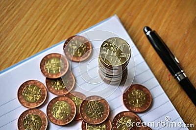 Pile of coins on the wooden table with a golden Czech Crown coin in the value of 20 CZK on the top Stock Photo