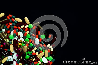 Pile of colorful tablets and capsules pills on black background. Global healthcare. Drug use in elderly people with chronic Stock Photo