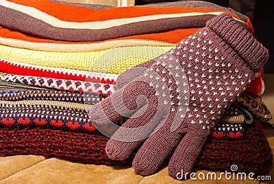 Pile of colorful warm winter Christmas clothes and a winter glove Stock Photo