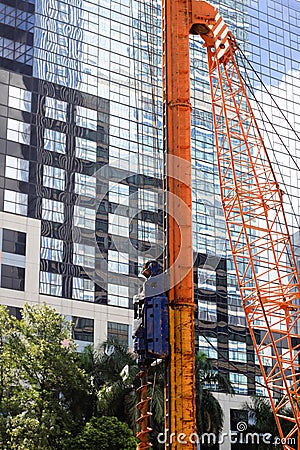 Pile construction crane in site around high rise glass building in Jakarta Indonesia Stock Photo
