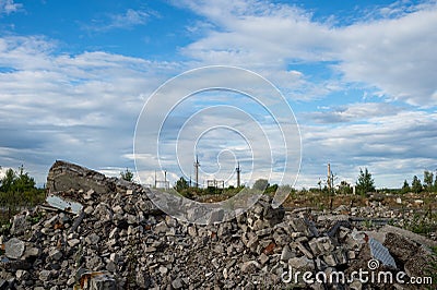 A pile of construction debris remains of a building on a vacant lot against the blue sky. Background Stock Photo