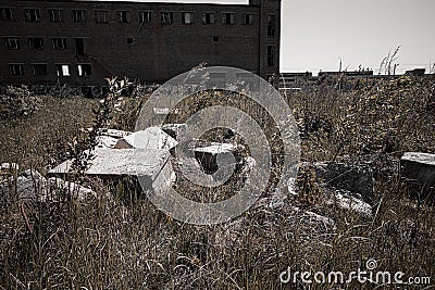 A pile of debris of destroyed building and Abandoned factory building with broken glass windows Stock Photo