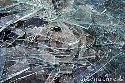 A pile of different sharp pieces of broken glass lying on the ground Stock Photo