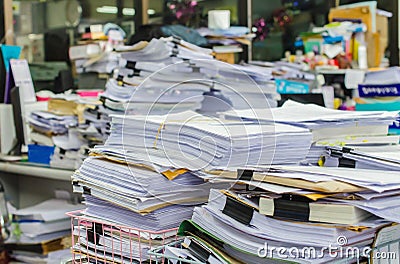 Pile of documents on desk stack up high waiting to be managed Stock Photo