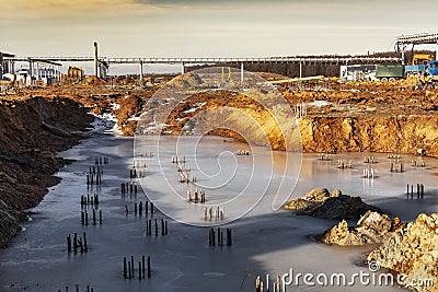 Pile field of bored piles flooded with water. Ice on the pile field. Frozen water in a pit at a construction site. Bored piles Stock Photo