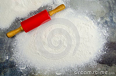 Pile of flour and rolling pin for rolling out dough on dark background of concrete table top Stock Photo