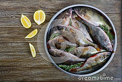 A pile of fresh raw fish on a tray on a wooden background. Top view. Carp. Stock Photo