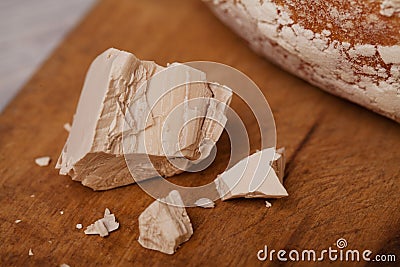 A pile of fresh yeast with a Homemade bread on old cutting board Stock Photo